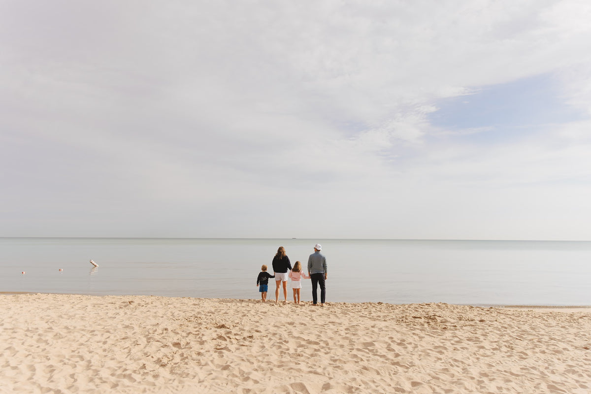 The Herrmann family at the edge of Lake Michigan on a wide open stretch of beach