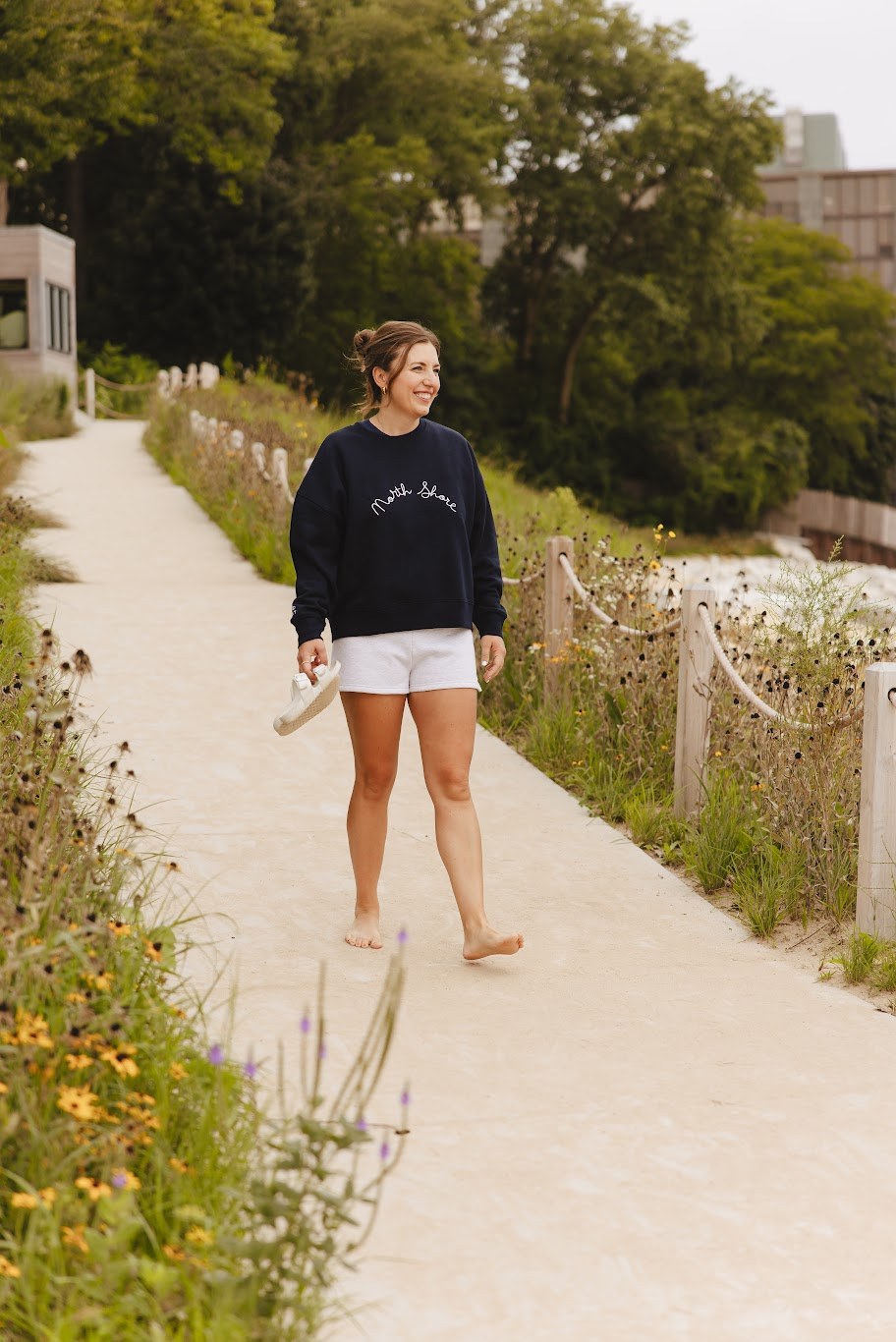 The North Shore crewneck in navy, on the path down to the beach